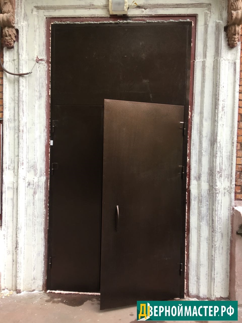 Металлическая входная дверь большого размера в подъезде